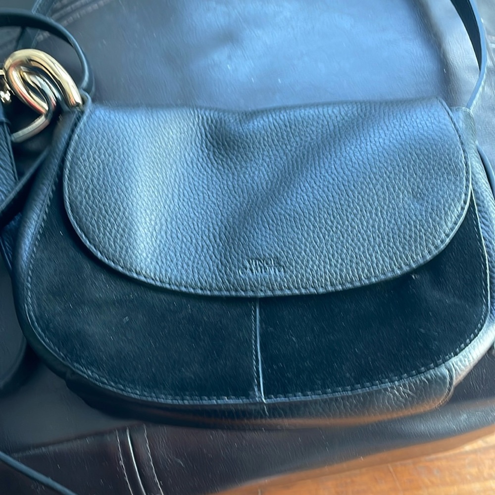 Black suede and leather crossbody bag with chain detail adjustable strap.